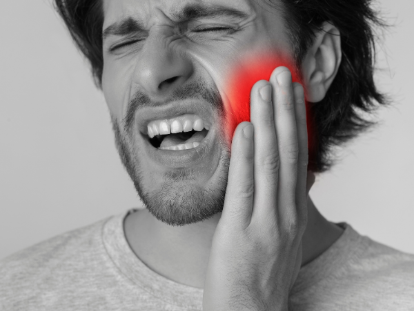 Woman experiencing toothache at emergency dentist in Wilmington