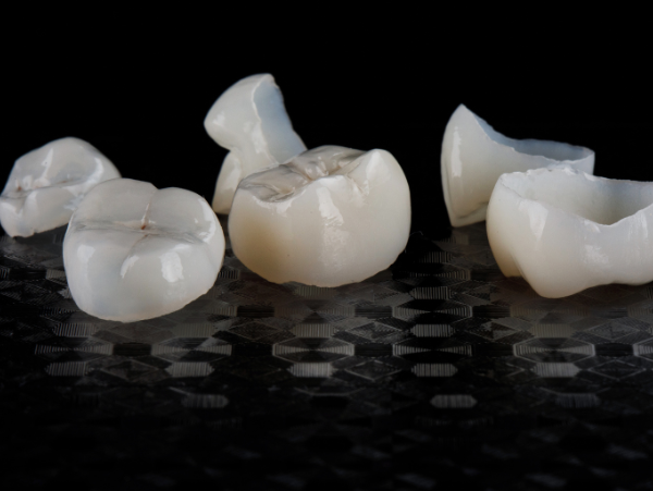 woman smiling holding her face l porcelain crowns wilmington