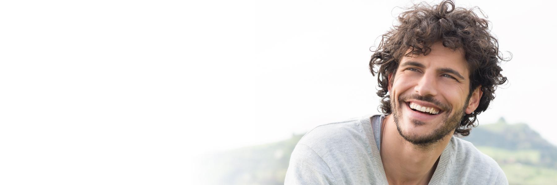 man with curly hair smiling l pike creek de dentist
