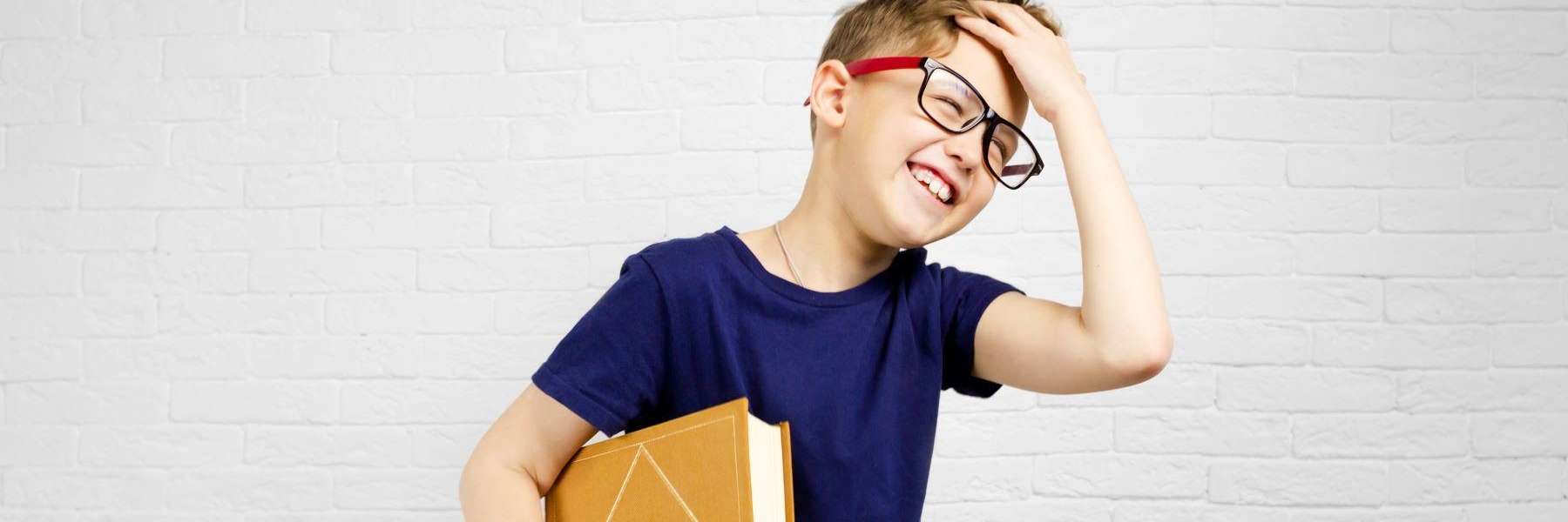 A smiling child holding his books | children's dentist