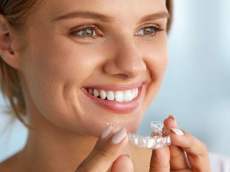 A woman holding her Invisalign tray