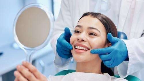 A dentist showing their patient their new cosmetic dentistry work