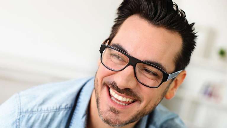 A laughing man with glasses | wilmington dentist