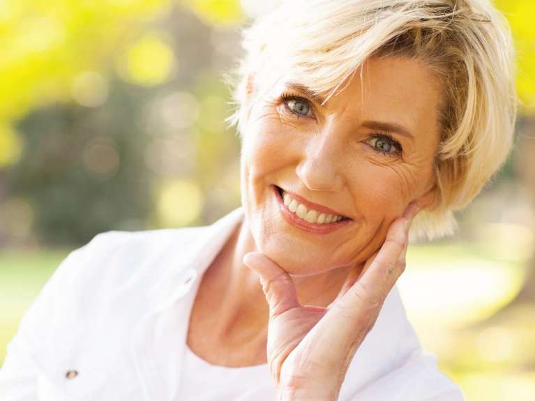 A smiling older woman with dental implants