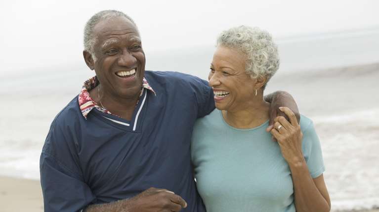 An older couple laughing on the beach | Wilmington dentist