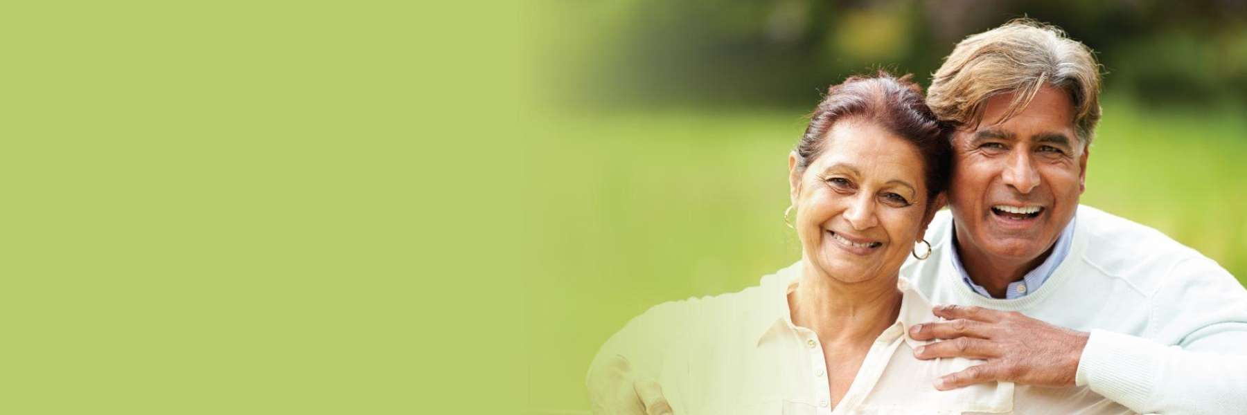 An older couple smiling in the park