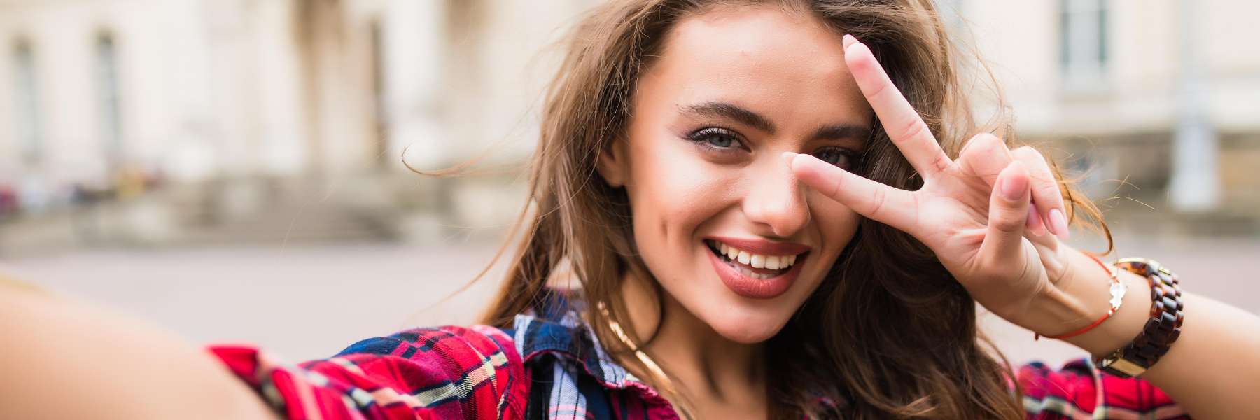 A smiling woman holding up the peace sign
