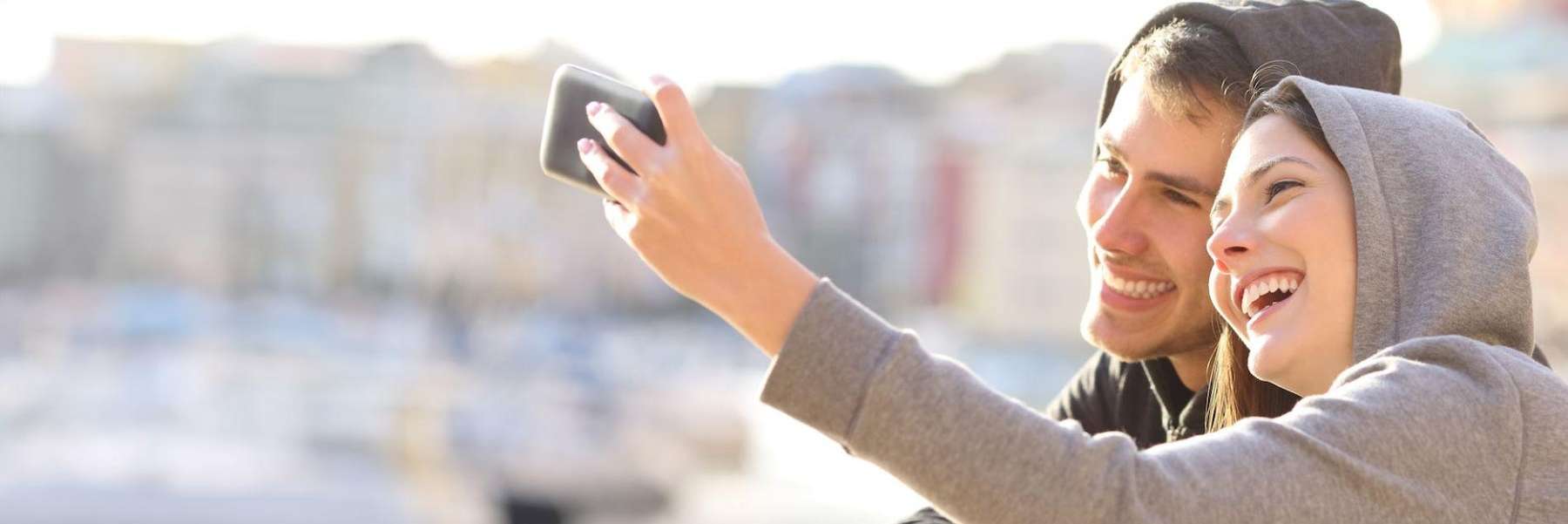 Two smiling people taking a selfie | teeth whitening Wilmington
